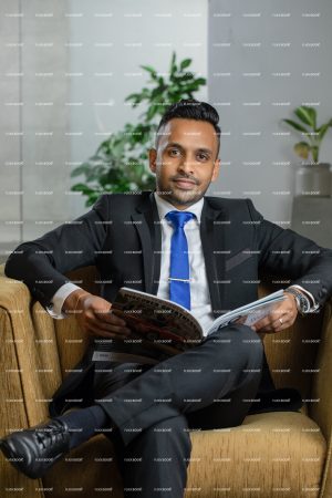 
									black suite, business, man, manager, professional, sitting in office, smart, holding a book, reading , smiling 