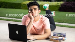 
									Emotions , a boy , laying down , casual outfit , thinking ,  posing , laptop , books , legs crossed , hand on chin , at a garden 
