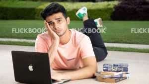 
									Emotions , a boy , laying down , casual outfit , thinking ,  posing , laptop , books , legs crossed , hand on chin , at a garden , sad , tired , stressed 