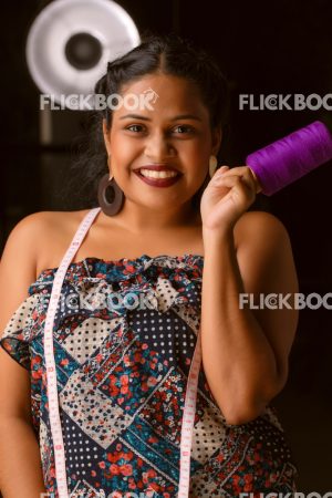 
									Fashion Design, A girl with red lipstick , tan girl , chubby girl , staring , posing , upward eyebrows ,  facial expressions , fashionable outfit , holding a measurement tape , smiling , standing ,  holding a thread cone