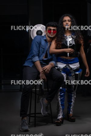 
									Fashion Design, a couple pic , A girl with blue lipstick , dark girl , curly hair , staring , posing , upward eyebrows , straight nose , facial expressions , dark skin , confident , standing , fashionable outfit , wearing a jean jacket , casual outfit , wearing sunglass , smiling , guy siting on a chair , guy’s head on girl’s shoulder 