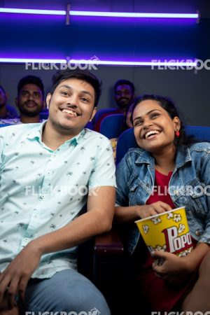 
									Entertainment , a couple , at movie theater , having popcorns , casual outfit , smiling , happy 