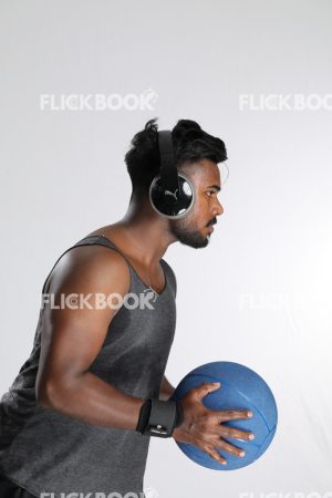 Man Wearing Headphones, Holding Mini Pilates Ball, Mini Exercise Ball, Getting Ready to Throw Ball, Strong Guy
