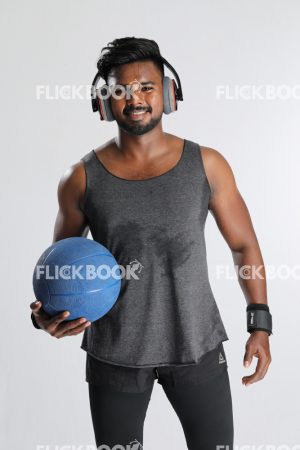 
									Fitness , holding a ball , wearing a headset , dark guy , wearing a skinny , sporty , well built body , smiling , happy 
