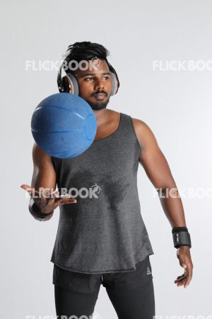 
									Fitness , holding a ball , wearing a headset , dark guy , wearing a skinny , sporty , well built body , looking somewhere , 