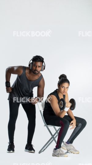 Fitness , a couple , sporty , girl holding a dummbbell , tired , sweaty , staring