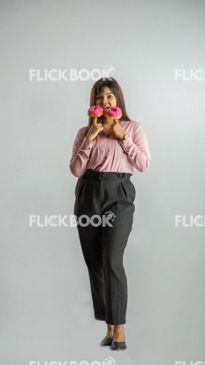 
									Food , A girl , holding two donuts from her fingers , smiling , office wear , standing 