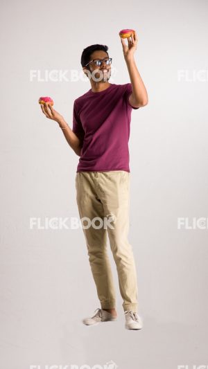 
									Food , A boy , holding two donuts  , smiling , casual outfit  , standing , staring , posing , 
