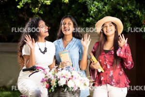 Entertainment, Three girls with a flower bicycle , at a garden , wearing a hat , casual outfit , smiling , happy , laughing  , waving hands 