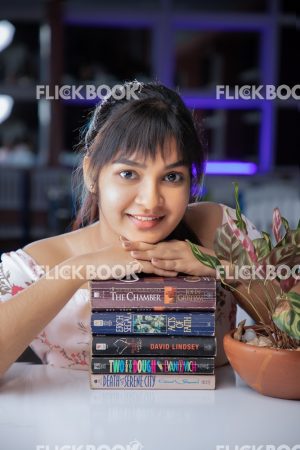 Library , books , smiling , casual outfit , sitting , happy , girl , chin on books 