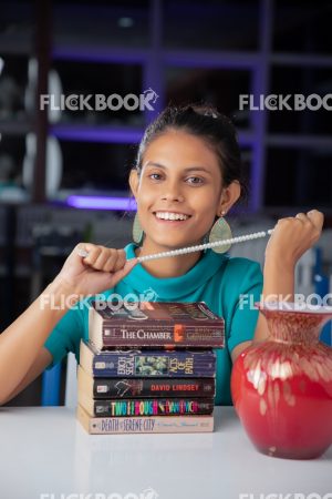 Library , books , casual outfit , sitting , happy , girl , staring , posing , smiling 