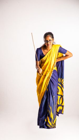
									Occupations , teacher , girl , file , standing , wearing saree , strict , punishing , stick 