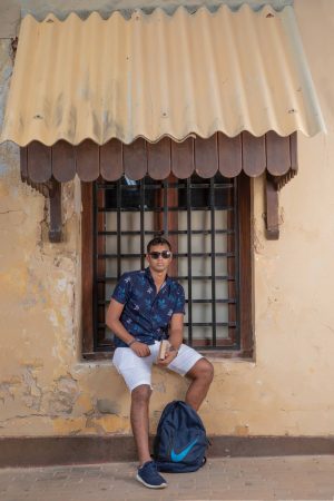 
									Travel , boy , sitting , holding a book , wearing sunglasses , casual outfit , posing 