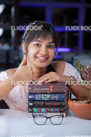 Library , books , smiling , casual outfit , sitting , happy , girl , thumbs up 
